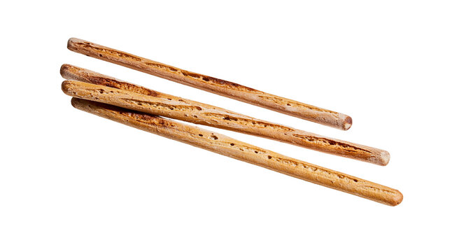 Isolated four thin crispy baked breadsticks, delicious snack or appetizer food item.