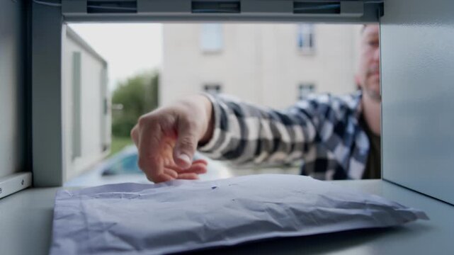 Man Picking Up Bubble Package Parcels From Self-Service Parcel Locker Outdoors, View From Inside A Compartment