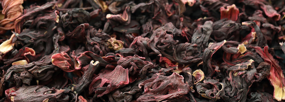 Dry egyptian hibiscus tea in big pile on table close up. Large amount of hibiscus tea leaves