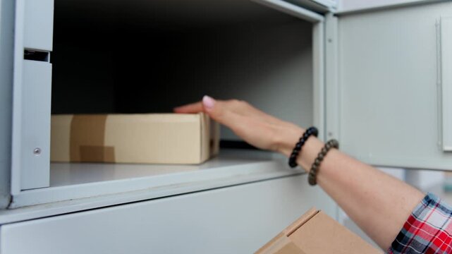 Woman Picking Up Cardboard Boxes At Street Automated Self-Service Delivery Lockers