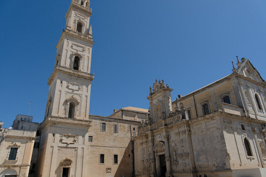 exterior view of the santa maria assunta cathedral of lecce, apulia. italian baroque architecture intricate limestone carvings and decorative stone details under a clear sky