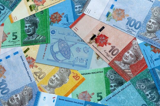 Malaysian ringgit money banknotes pile on table. Malaysia bills of MYR currency close up