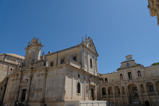exterior view of the santa maria assunta cathedral of lecce, apulia. italian baroque architecture intricate limestone carvings and decorative stone details under a clear sky