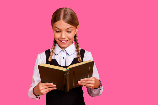 Close-up portrait of her she nice attractive lovely cheerful cheery smart clever intelligent pre-teen girl holding in hand interesting book isolated over bright vivid shine orange background