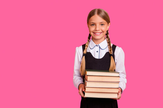 Portrait of her she nice attractive confident cheerful cheery smart clever blonde pre-teen girl holding in hands carrying book pile first grade isolated over bright vivid shine orange background