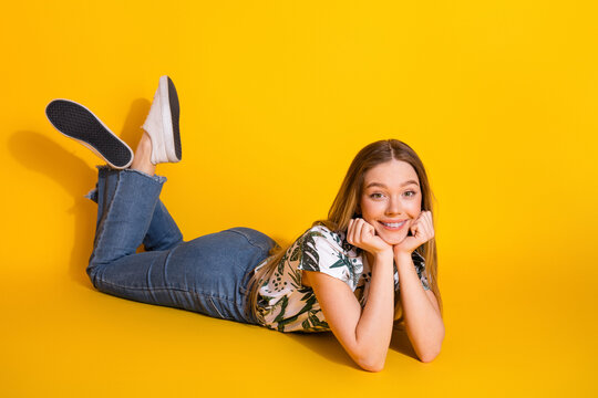 Cheerful young woman posing on yellow backdrop wearing casual summer attire, exuding joy and positivity in lifestyle setting