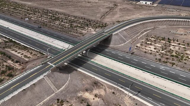 aerial view of modern highway interchange bridge in arid desert landscape