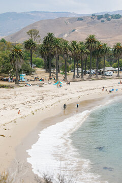 wide angle shots of Refugio Beach in Santa Barbara, California with surfers, palm trees, and mountains in the background