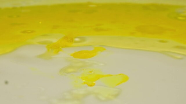 Window glass cleaning with yellow soapy solution, cleaning liquid flowing on office window, professional glass cleaning service close up macro
