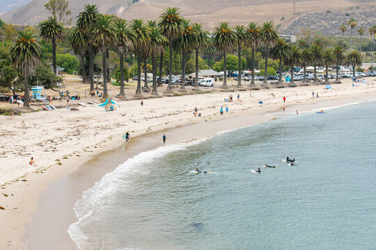 wide angle shots of Refugio Beach in Santa Barbara, California with surfers, palm trees, and mountains in the background