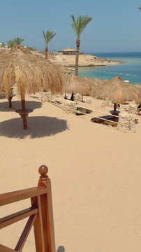 Serene beach with thatched umbrellas and turquoise sea in sunny paradise Egypt. Hurghada