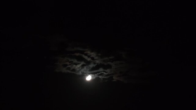 Curious stratocumulus clouds moving in the sky with the moon shining