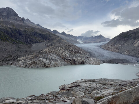 The Rhone Glacier Descends Toward a Grey Alpine Lake in Switzerland