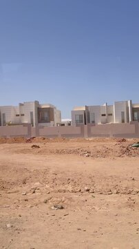 Modern desert villas behind concrete wall under clear blue sky Egypt. Hurghada