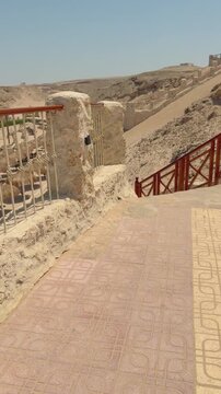 Scenic desert pathway with red wooden gate and stone walls Egypt. Hurghada