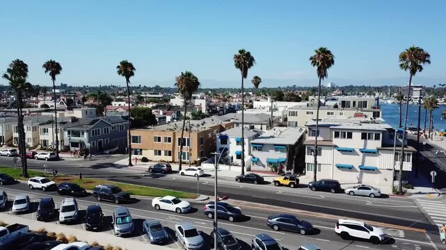 Belmont Shore, California, USA - Aerial drone footage rising above Horny Corner and revealing beachfront homes, the 2nd Street area, sandy shoreline, and coastal community in bright daylight