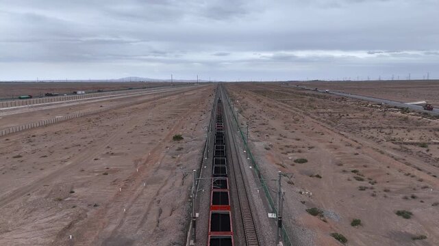 coal train traveling on railway tracks in desert