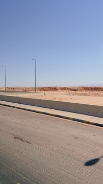 Empty desert road with streetlamps under clear blue sky Egypt. Hurghada