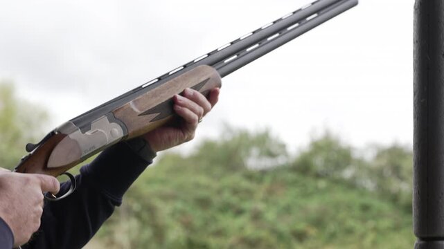 Man aims following target and shoots shotgun firing range