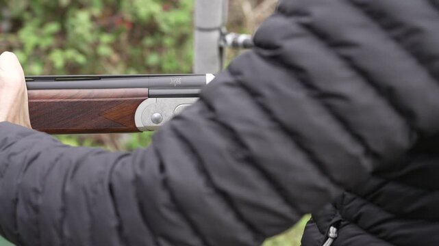 Woman opens and ejects shotgun cartridges gun smoke close up