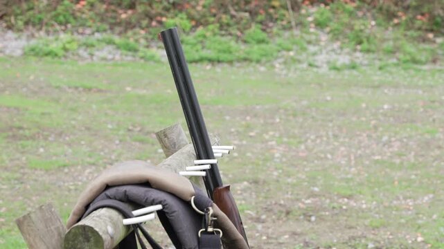 Man picks up shotgun gun from shooting range stand