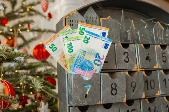 Euro Banknotes in Metal Christmas Advent Calendar. December gifts. calendar drawers near a glowing Christmas tree. for holiday savings, preparing an annual Christmas fund, financing expensive gifts