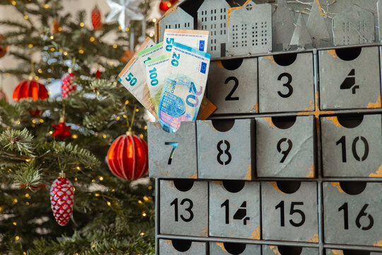 Euro Banknotes in Metal Christmas Advent Calendar. December gifts. calendar drawers near a glowing Christmas tree. for holiday savings, preparing an annual Christmas fund, financing expensive gifts