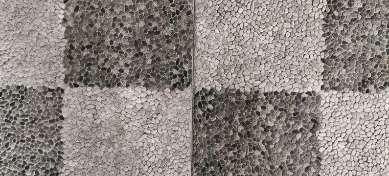 Black and white pebble mosaic floor pattern in checkerboard style texture.