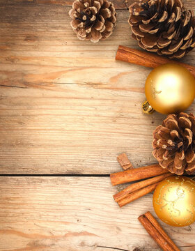 Rustic Christmas ornament, pine cone, and cinnamon stick on wooden background create warm festive holiday arrangement