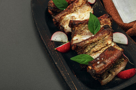 Baked pork ribs with spices, vegetables and sauce. Traditional ingredient for BBQ, picnic concept