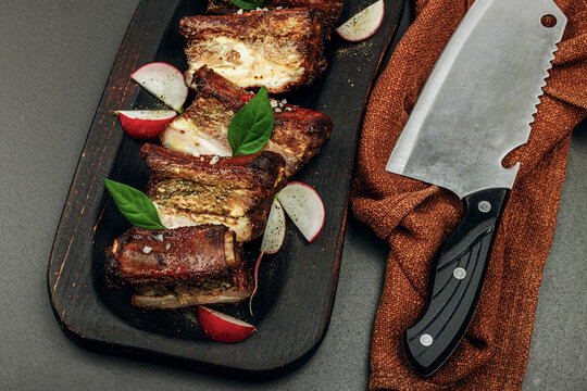 Baked pork ribs with spices, vegetables and sauce. Traditional ingredient for BBQ, picnic concept