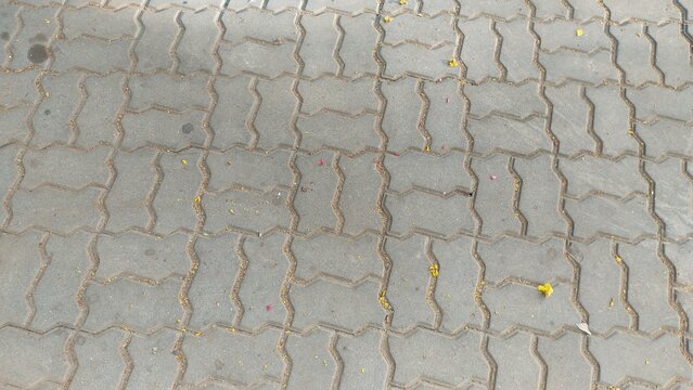 Gray interlocking paving stones texture surface background, modern pavement design for outdoor urban paths and pedestrian walkways