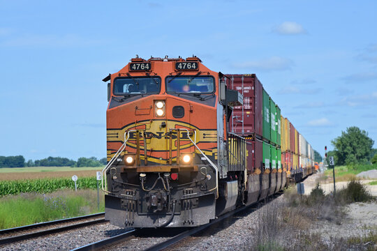 A lone Burlington Northern Santa Fe locomotive provides front-end power for an eastbound stack train as it approaches a diamond crossing in Rochelle, Illinois.