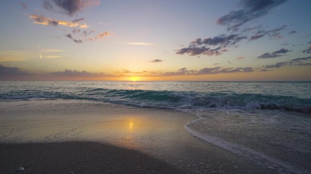 Dramatic Florida beach at sunset with golden light reflecting on ocean waves, colorful sky and tranquil shoreline creating a serene tropical seascape with cinematic atmosphere.