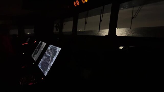 cargo ship navigation bridge during night watch.