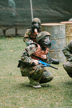 Paintball Players Crouching Outdoors in Protective Gear