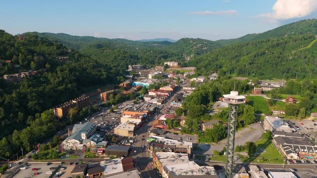 Gatlinburg, Tennessee city tourist area with busy Parkway street, popular shops, restaurants and scenic mountain backdrop.