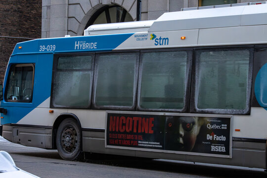 MONTREAL, CANADA, 22 December 2025 : Hybrid city bus advertisement cold weather urban transportation