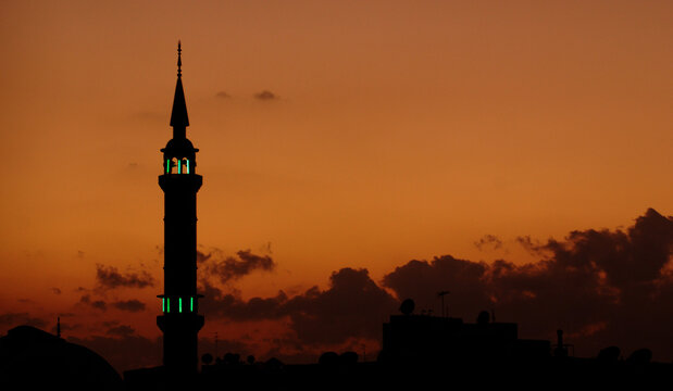 Silhouette of a Mosque near nile river at sunset Assouan Egypt. A breathtaking silhouette of a mosque against a fiery sunset sky over the Nile River is one of the most iconic images of Aswan Egypt