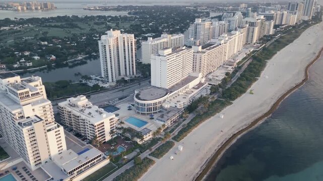 Drone glide over miami beach high rises between waterway and shoreline