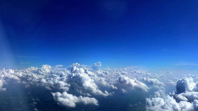 Flying through the clouds aerial view from airplane blue sky