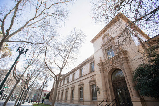 Bare winter trees frame historic architecture in downtown San Jose, California, USA.