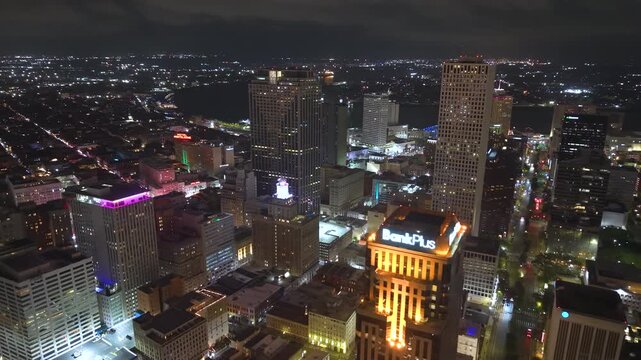 New Orleans, Louisiana at night with downtown modern architecture, illuminated office buildings. City lights emphasize scale of urban skyline.