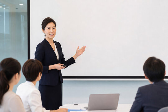 会議室でスクリーンを使って説明する女性
