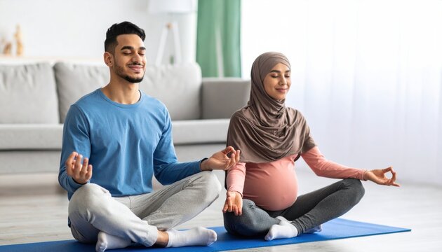 Happy Middle Eastern Couple Meditating at Home, Pregnant Woman and Man Practicing Yoga Together