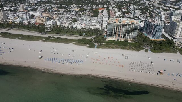Aerial pass above miami beach reveals a sunlit strip of sand and towers
