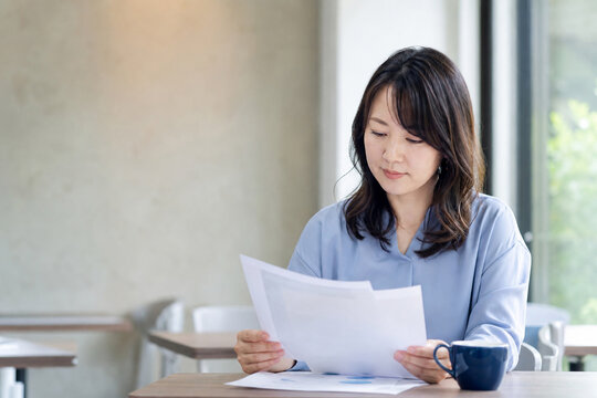 カフェで書類を確認する女性