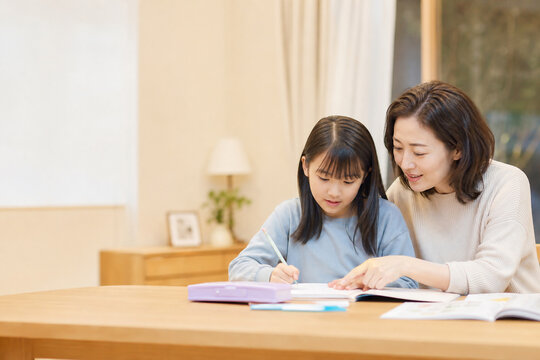 自宅で勉強する娘を見守る母親