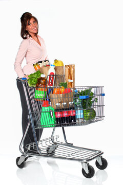 Happy Woman Pushing Full Shopping Cart of Groceries studio shot on white
