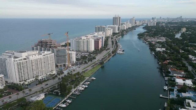 Aerial voyage along a miami beach canal toward distant golf greens